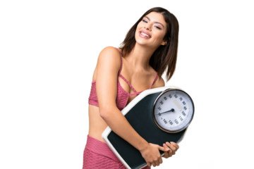 Young Russian woman with rainproof coat and umbrella over isolated chroma key background with weighing machine