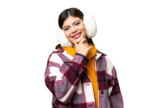 Young Russian woman wearing winter muffs over isolated chroma key background smiling