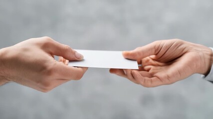 Person hands over blank business card to another individual, symbolizing networking, partnership, or introduction. Focus is on hands, card, emphasizing connection, professionalism