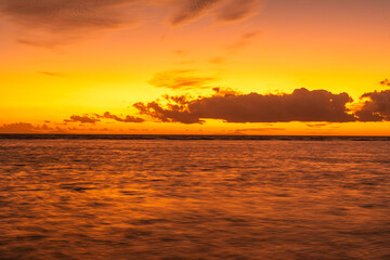 Romantic sunset at Anse Source d’Argent, with golden light reflecting on the turquoise water, iconic granite boulders, and a dreamy tropical beach setting
