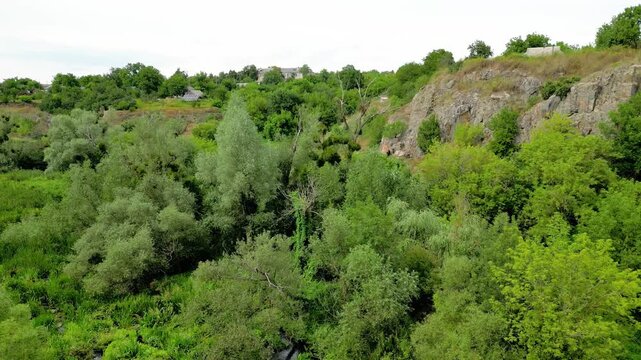 Experience the breathtaking views of Buki's canyon in Ukraine from above. This captivating aerial view highlights the rich greenery and stunning rock formations in this serene landscape.