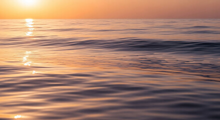 Golden sunlight reflecting on the gentle waves of the ocean at sunset time