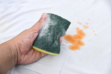 hand hold bubble with cleaning soap for clean dirty stain on shirt fabric