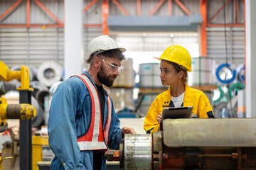 female engineer supervisor advice technician foreman to inspect and check spare part equipment of production machine, team of diverse workers working together at industrial manufacturing factory