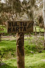 Vertical image of a wooden sign of the with the text 