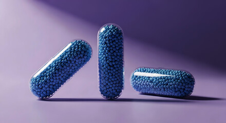 Three transparent capsules filled with small blue spheres on purple background pill medicine