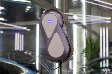 Automated window cleaning robot on a large glass pane in a bright modern apartment. Automatic window cleaning robot washing glass in high-rise building, providing convenience, efficiency for home. 