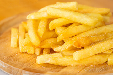 French fries, potato fry sprinkled with salt in a wooden plate, Close-up