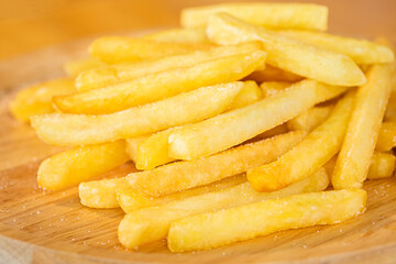 French fries, potato fry sprinkled with salt in a wooden plate, Close-up