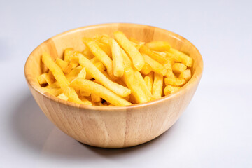 Fried french fries (potato fries) in a wooden bowl on white background