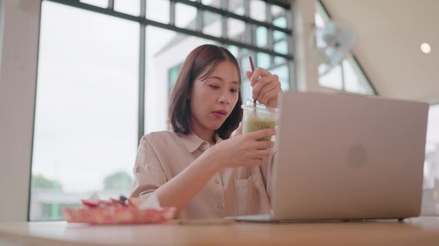 Serene Work-Life Blend A person in a cafe, absorbed in a work session while preparing and enjoying a matcha drink, alongside a plate of strawberries.