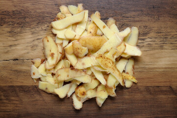 Potato peelings heap on wooden table surface top view
