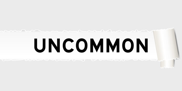 Ripped gray paper background that have word uncommon under torn part