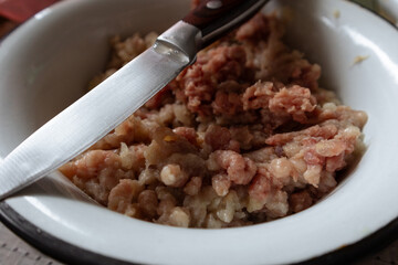 Sharp knife on a bowl of minced meat