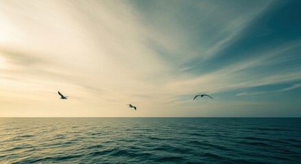 Flock of seabirds in flight above the sea. Natural wildlife and freedom concept. Serene ocean horizon with dramatic sky for meditation or wellness. Travel and exploration theme
