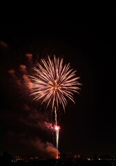 A vibrant firecracker firework bursts brightly against a dark sky, showering colorful sparks and smoke, signaling a joyful celebration ,smoke ,blue ,dangerous