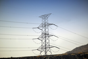 Fototapeta premium Power transmission tower providing energy across a mountainous landscape