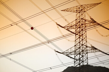 Dramatic power lines against warm gradient sky for infrastructure projects