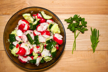 Summer Salad: Fresh Radish and Smashed Cucumbers with Parsley on a Wooden Table