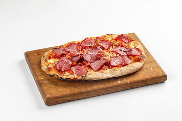 Freshly baked flatbread pizza with cheese and sliced cured meat served on wooden board over white background