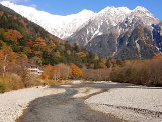 山頂の冠雪の白、木々の緑、カラマツの金に秋の上高地が彩られる