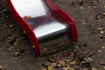 A shiny children's slide on a playground in autumn