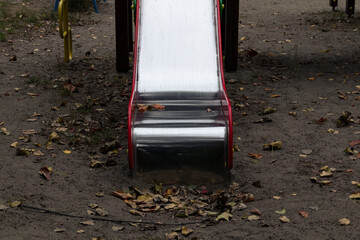 Clean and shiny children's slide on an empty playground in autumn