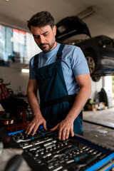 Mechanic organizing tools while working in an auto repair shop
