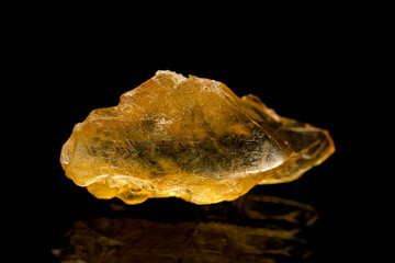 Natural rough golden yellow barite (baryte) mineral crystal on dark background (selective focus)