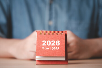 Desk calendar showing 2026 start in front of businessman which symbolizing new year beginning business planning fresh goals and motivation for future success and positive change concept