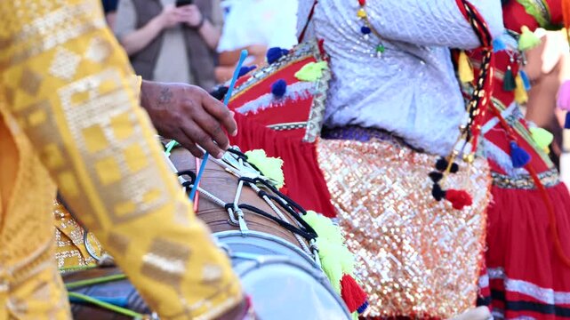 Dhol drummer playing traditional Indian music during a cultural festival celebration