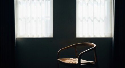 Modern designer chair in a minimalist dark room. Dramatic window light creating high contrast shadows. Conceptual scene for solitude introspection and waiting. Empty space for text