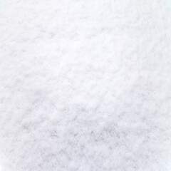 Close-up texture of fresh white snow, creating a soft and clean winter background perfect for Christmas designs, seasonal cards, and cold-weather themed projects.