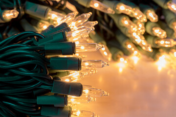 New Christmas string lights turned on and glowing. Holiday decoration safety and lighting concept.