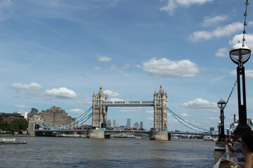 Obraz premium View of Tower Bridge in London under a clear blue sky with fluffy clouds on a sunny day