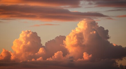 Majestic cumulus clouds glowing at sunset. Warm golden hour light on a dramatic cloudscape. Ethereal sky for spiritual or relaxation concepts. Abstract nature scenery with pastel colors