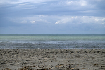 Mediterranean Beach at Tore del lago Puccini. Autumn sky with little sun. Reflections in water.