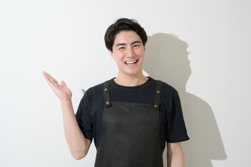 案内をするエプロンをつけた日本人男性