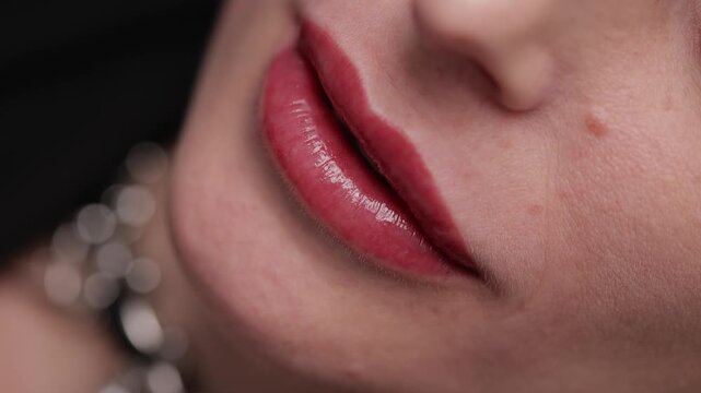 Fashion video of lip tattoo procedure on female lips with tattoo machine.