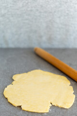 Preparing dough for cheese sticks with rolling pin, side view