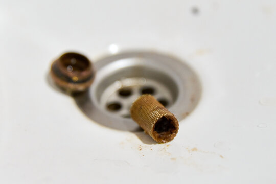 Removal and cleaning of clogged strainer filter mesh in drain