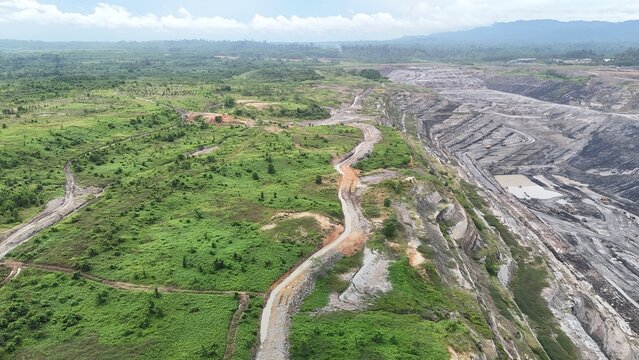 The image shows an aerial view of a rural landscape featuring a network of winding canals or small rivers crossing through green and brown terrain. open channel at reclamation of mining project
