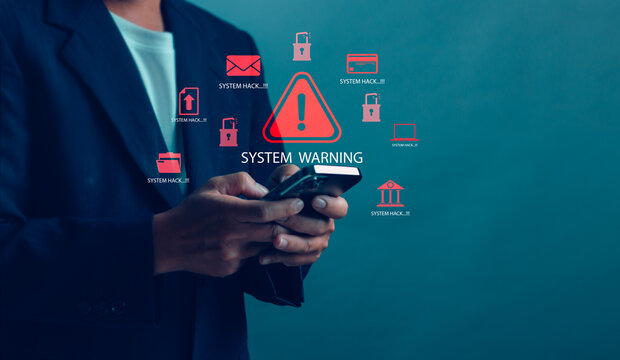 Closeup of a businessman holding a smartphone with digital system warning and hacking alert icons. Concept of cyber attack, online data breach, digital security risk and information theft