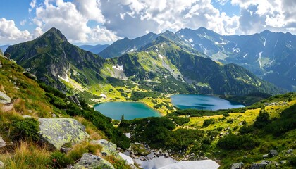 Stunning panoramic view of a mountain range with lakes under a cloudy blue sky