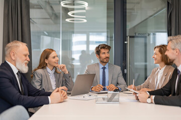 Happy five business people executive team working at laptop having discussion at office meeting showing financial project