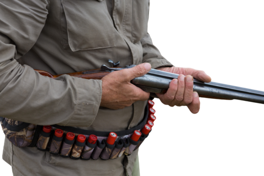 Hunter man in camouflage with a gun during the hunt in search of wild birds or game. Autumn hunting season.