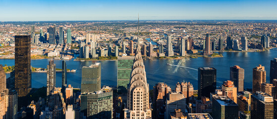 Aerial panoramic view of Midtown Manhattan skyscrapers and East River with Queens and Long Island...