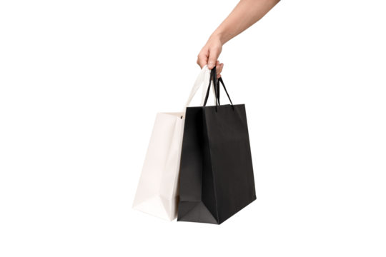A person's hand holding a paper shopping bag with handles on a clean white background. Studio shot with ample copy space for text, logos, or branding. Isolated on white, cut out.
