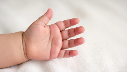 Obraz premium A child's palm with open fingers, a baby's hand on a soft white background