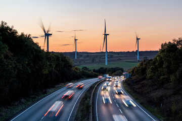 Wind turbines and highway traffic creating renewable energy concept